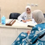 طبيبة بقسم الحساسية والمناعة أثناء توقيع الكشف الطبي على إحدى المريضات
