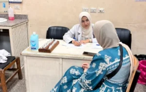 طبيبة بقسم الحساسية والمناعة أثناء توقيع الكشف الطبي على إحدى المريضات